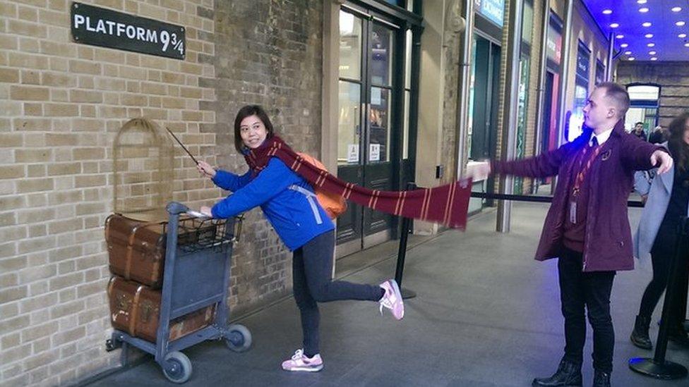 People having their picture taken at Platform 9 and 3/4s