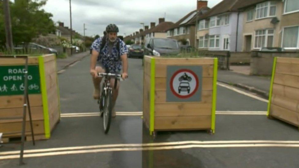 Man on bike riding through LTN planters