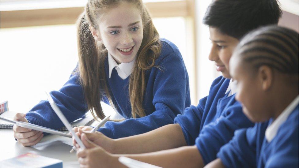 Three pupils next to a window at school