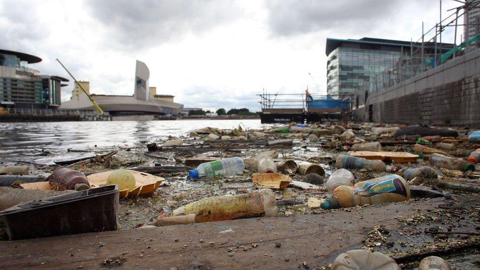 Plastic bottles, footballs and floating rubbish pollutes Manchester Ship Canal at Salford Quays