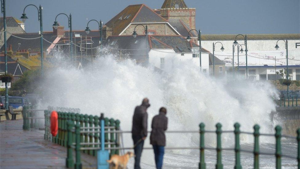 A couple watch waves break on the sea wall at Penzanze, Cornwall, as Hurricane Ophelia hits the UK and Ireland with gusts of up to 80mph