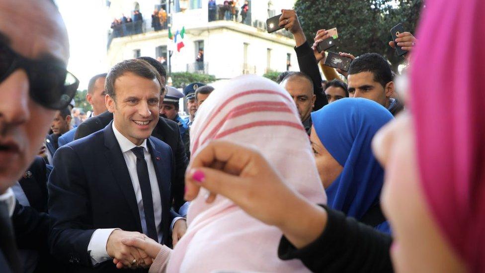 French President Emmanuel Macron greets people in the streets of Algiers on December 6, 2017. Macron began his first official trip to Algeria, announcing that he was visiting as a 'friend' despite France's historically prickly relationship with its former colony.