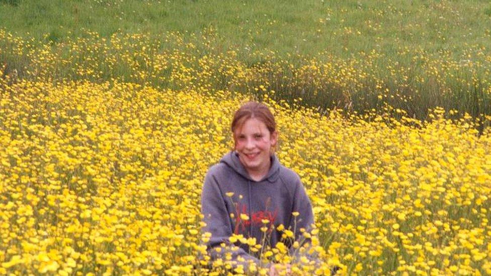 Milly standing in field of flowers