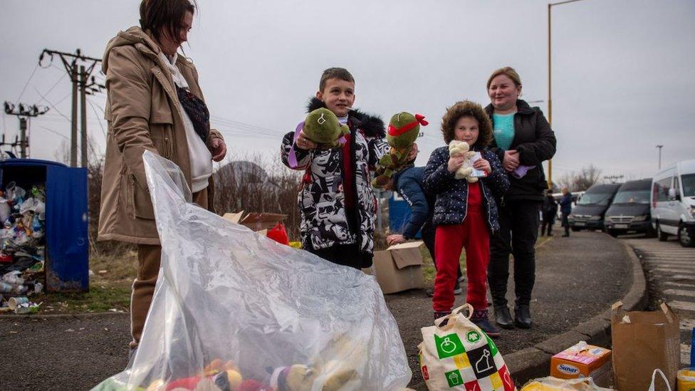 Ukrainian children take free toys offered by Slovak volunteers after they crossed the border in Vysne Nemecke, eastern Slovakia