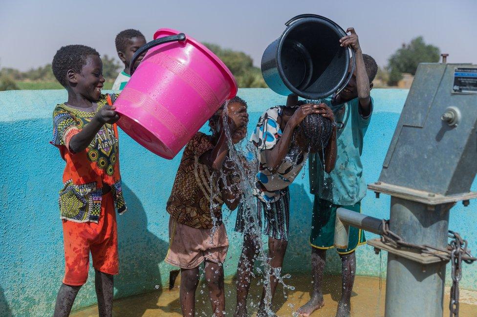 Children wash and play in clean water at a WaterAid pump