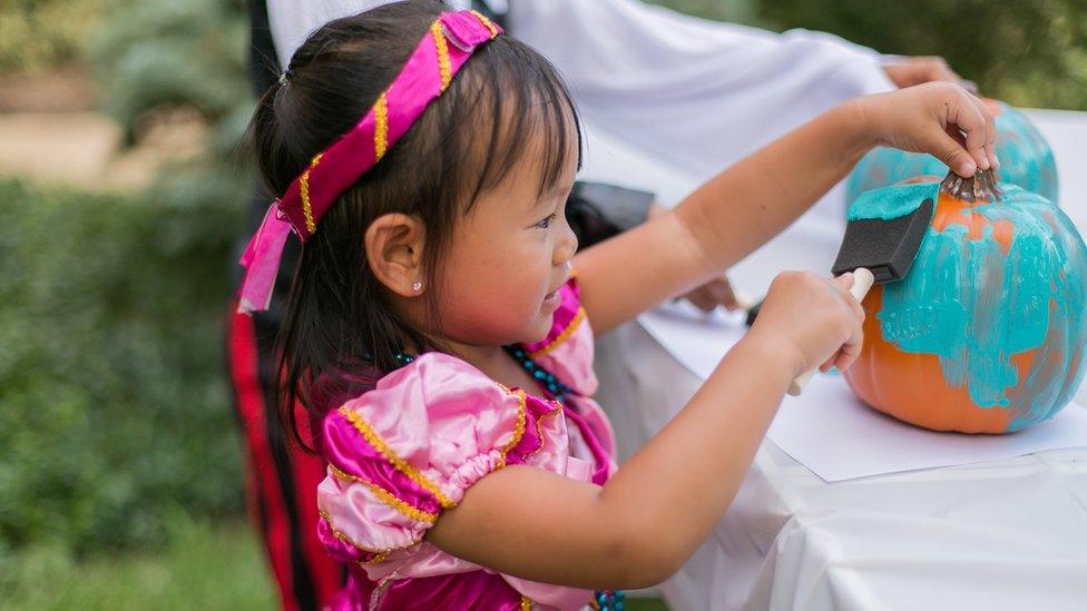 Girl painting a pumpkin