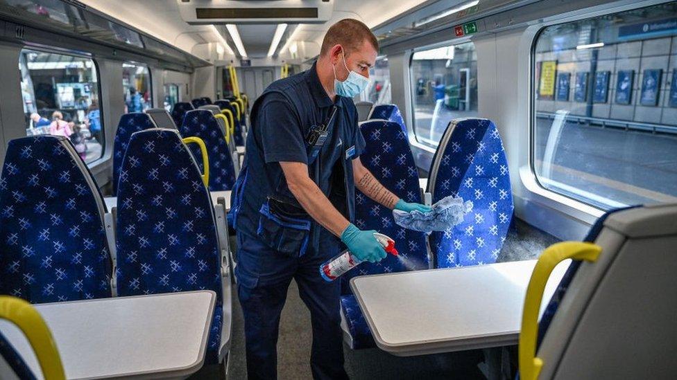 A member of railway staff cleans a train at Waverley Station