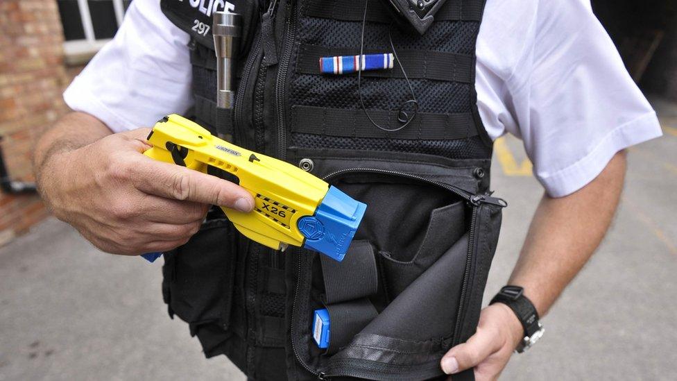 File photo from 2009 of an Avon and Somerset police officer holstering a Taser X26 during training