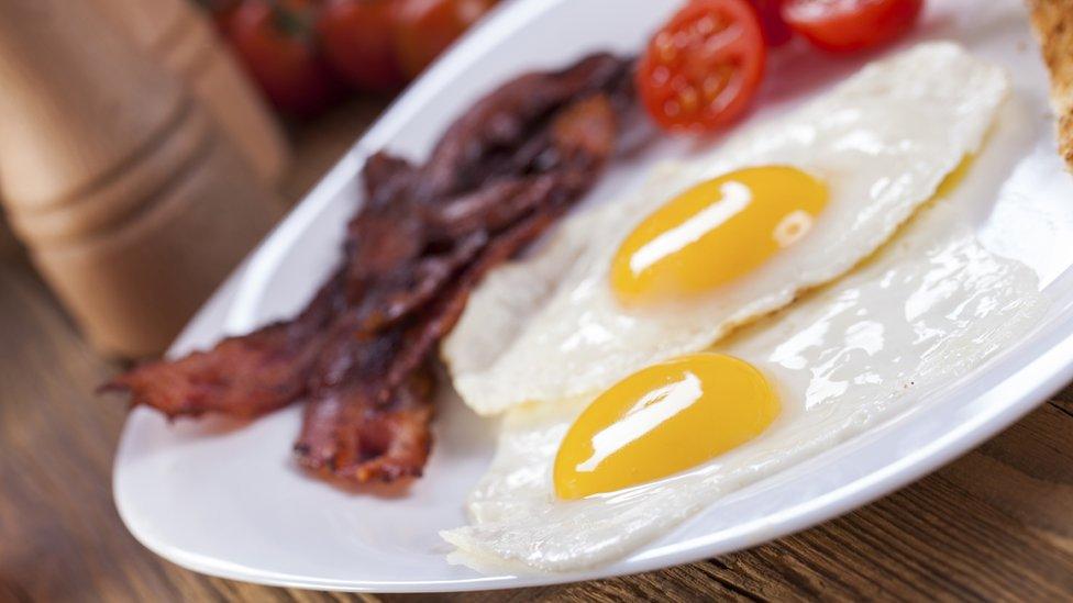 Plate of bacon, eggs and fried tomato