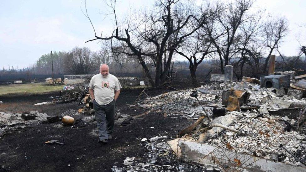 Property owner Adam Norris surveys the damage at his home outside the town of Drayton, Alberta, on, May 08 2023.