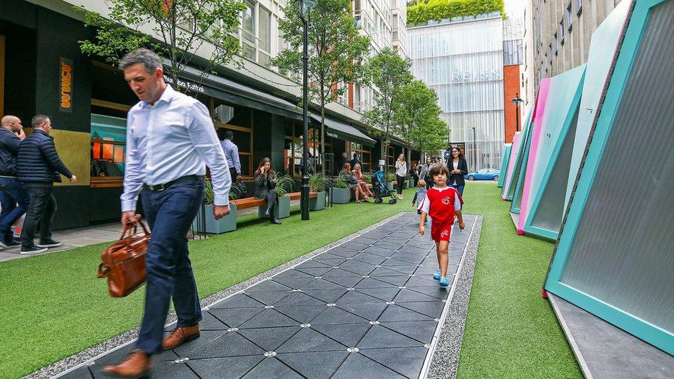 Pedestrians trying out a Pavegen pavement