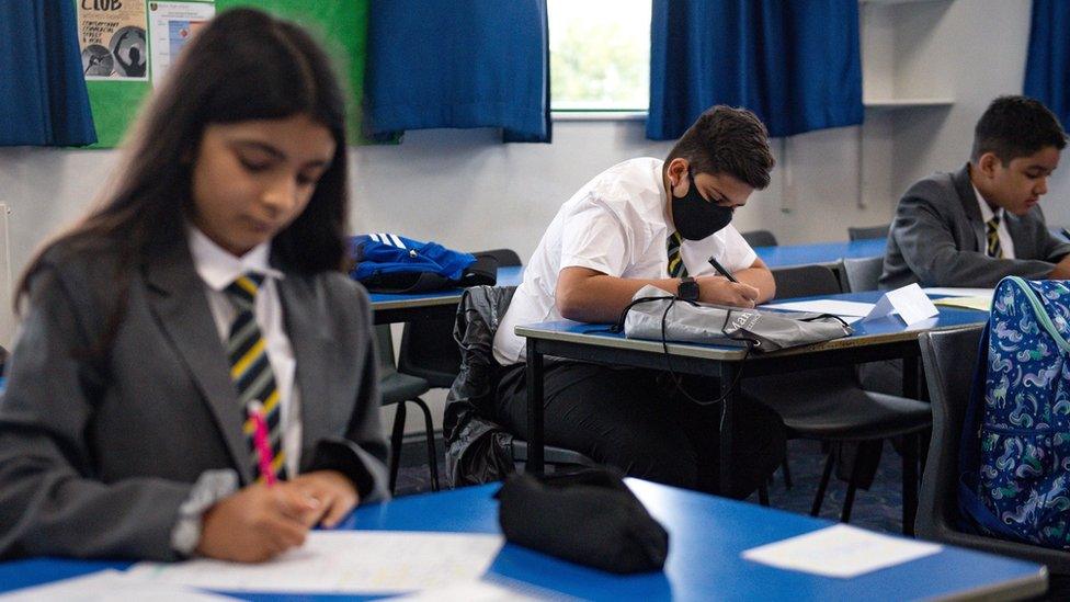 A pupil wears a face covering in a school classroom in Leicester