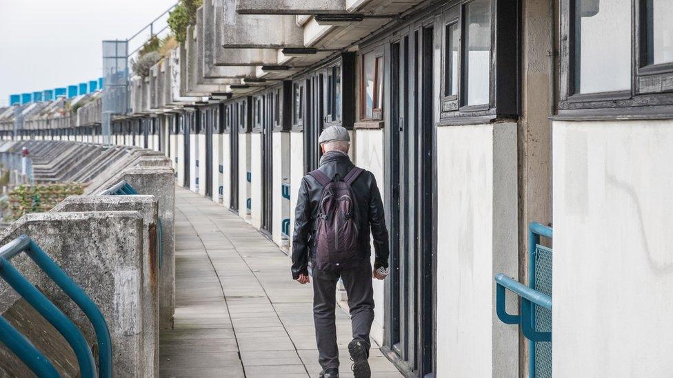 Man walking along houses in London