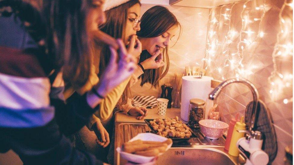 Young women eating near sink