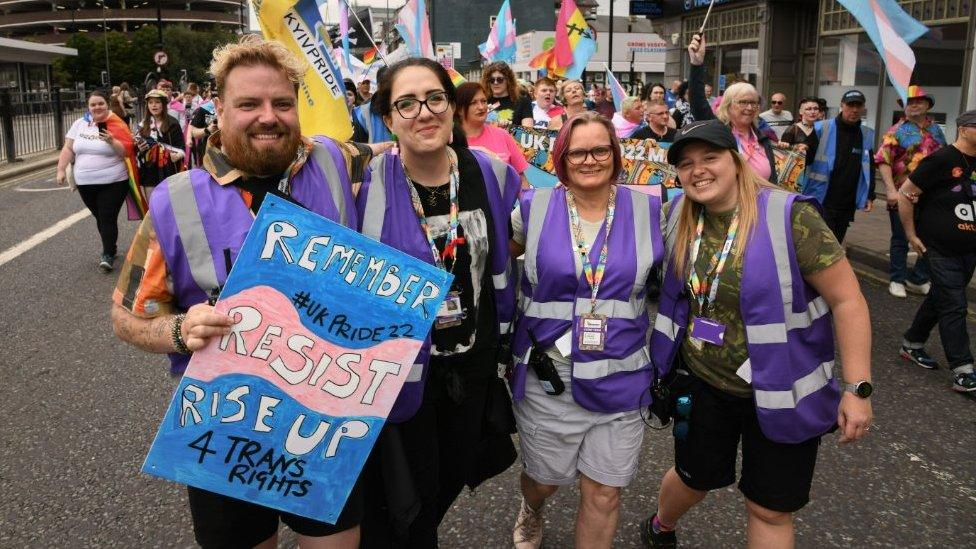 Four organisers in high vis jackets march