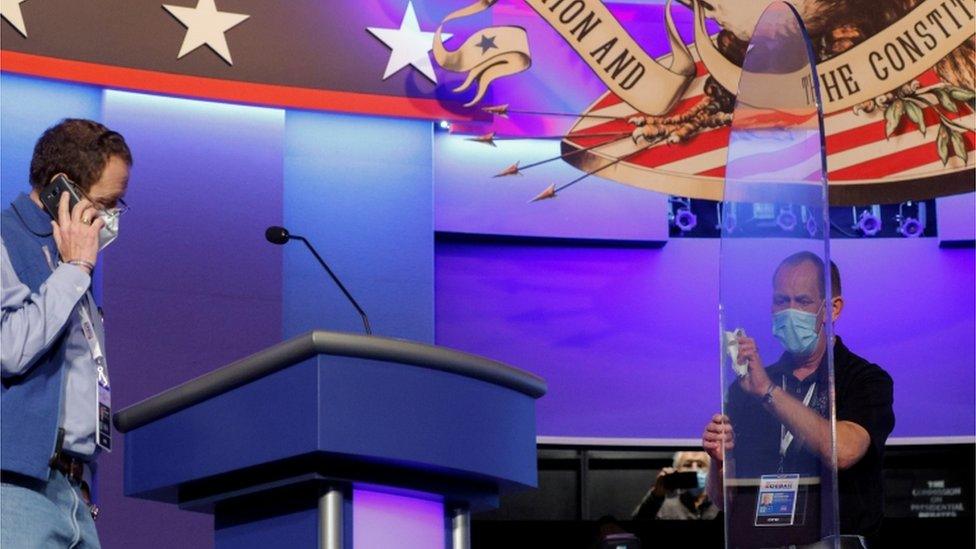 A worker cleans the plexiglass shields onstage at the site of the final debate between U.S. President Trump and former Vice President Biden in Nashville, Tennessee worker cleans the plexiglass shields onstage at the site of the final debate between U.S. President Trump and former Vice President Biden in Nashville, Tennessee