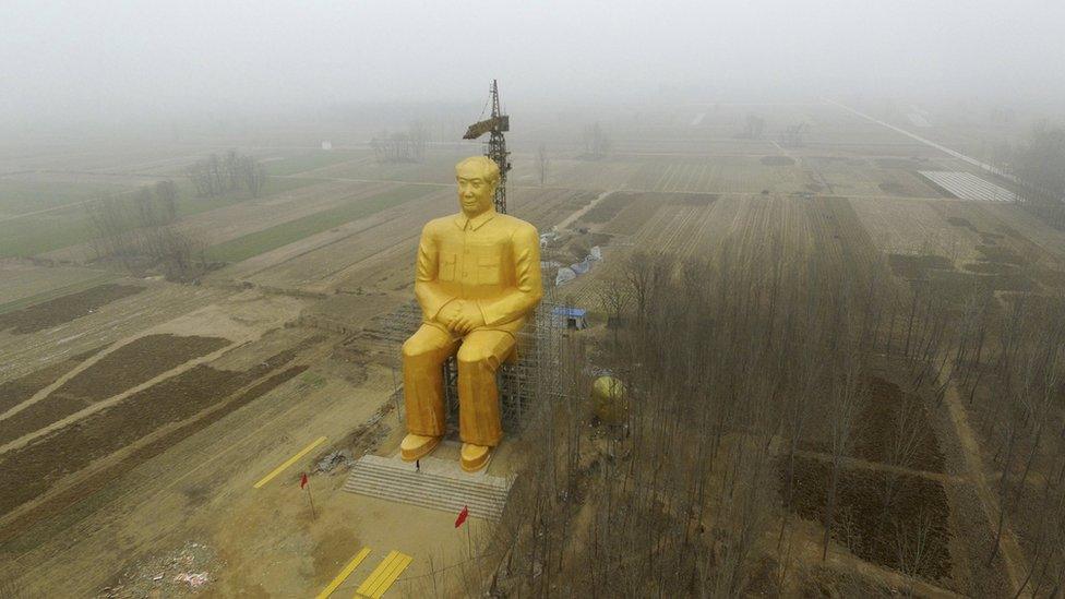 The statue, surrounded by fields