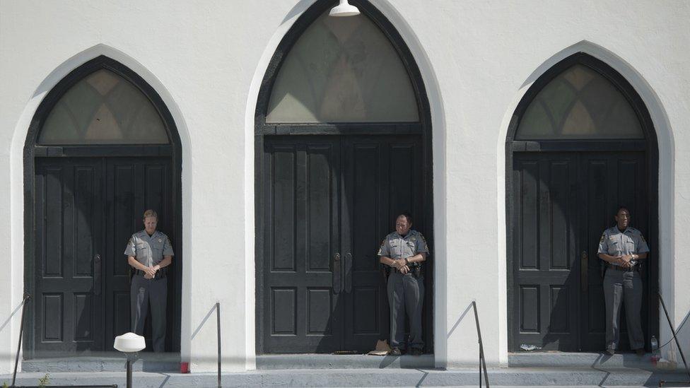 2015-06-21. Police officers stood guard during a Sunday service at Emanuel AME Church in Charleston. Colm O'Molloy for BBC News.