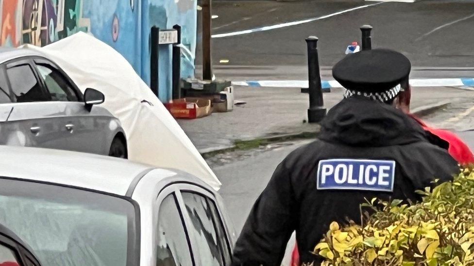 A white tent placed on a road that's cordened off by police