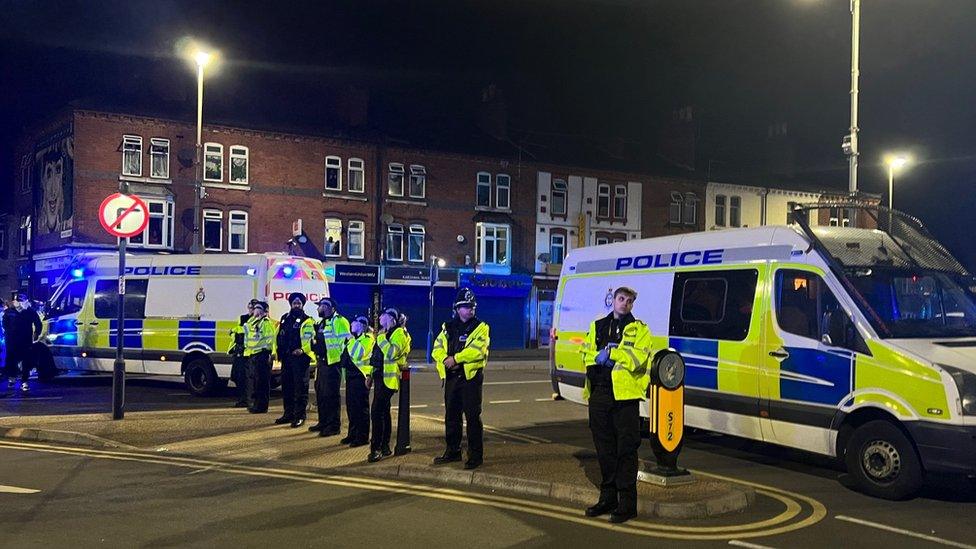 Police officers in street and police vans