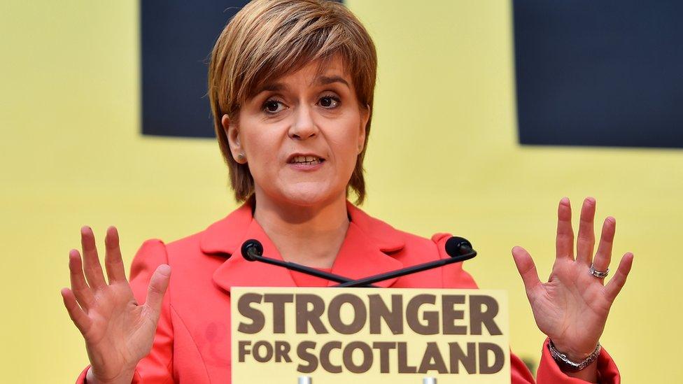 Nicola Sturgeon delivering the SNP manifesto in front of a Stronger for Scotland sign