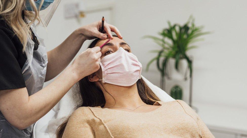 Woman receiving an eyebrow treatment.