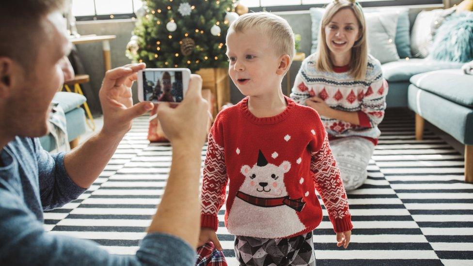 A little boy and adult wearing Christmas jumpers