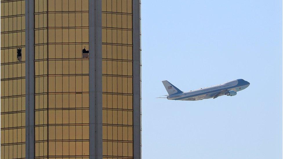 Air Force One passes to the right of the gold-coloured windows of the Mandalay hotel, two of which are shattered from the gunfire during the attack