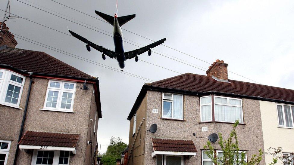 Plane flying over a housing estate outside Heathrow Airport