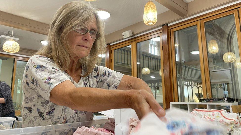 A baby basket is being prepared by a volunteer