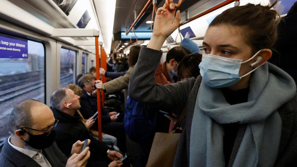 Commuters, some wearing face coverings, travel on a packed London Overground train service on 1 March 2022