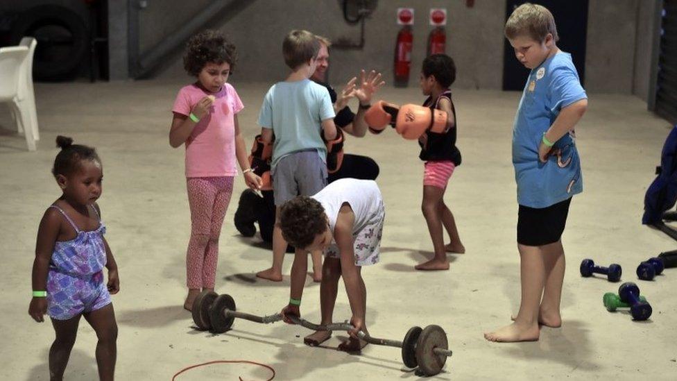 Children entertain themselves in a temporary cyclone shelter in the town of Ayr in far north Queensland as Cyclone Debbie approaches on March 28, 2017