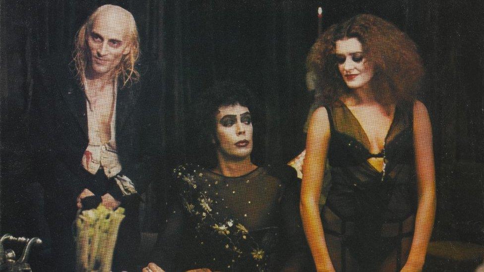 Patricia Quinn, Richard O'Brien and Tim Curry as their characters Magenta, Riff Raff and Dr Frank N Furter at the dinner table in the Rocky Horror Picture Show