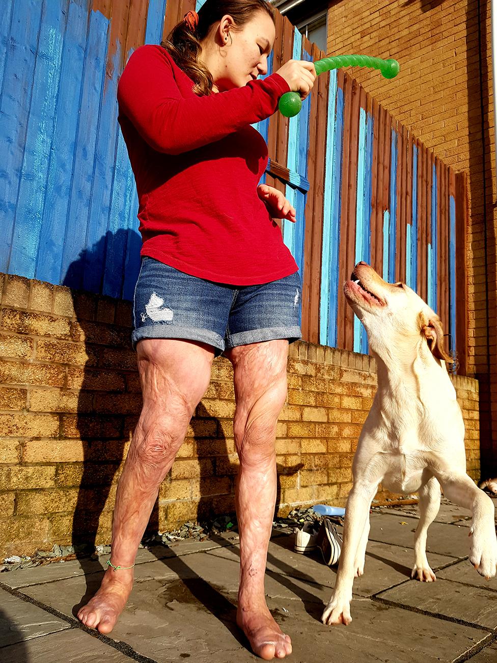 Laura plays with her dog