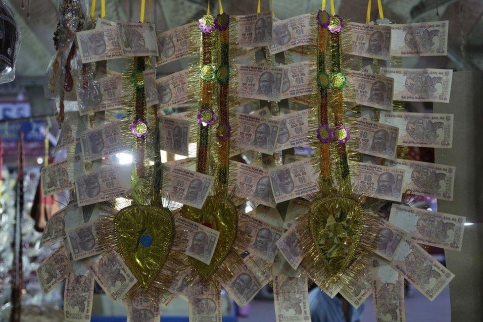 Garlands made of Indian 10 Rupees denomination are displayed for sale, in Allahabad, India, Sunday, Nov. 13, 2016.