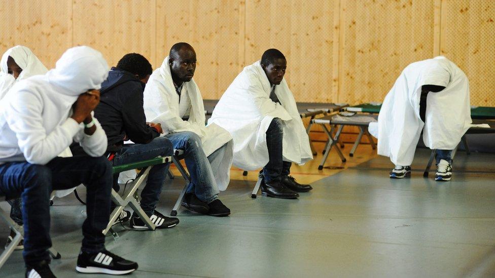 Refugees wait to be registered in a police sports hall in Rosenheim, Germany, 03 September 2015