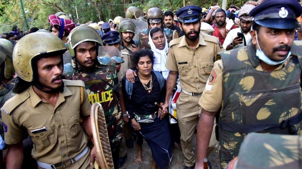 The women are surrounded by police and protestors