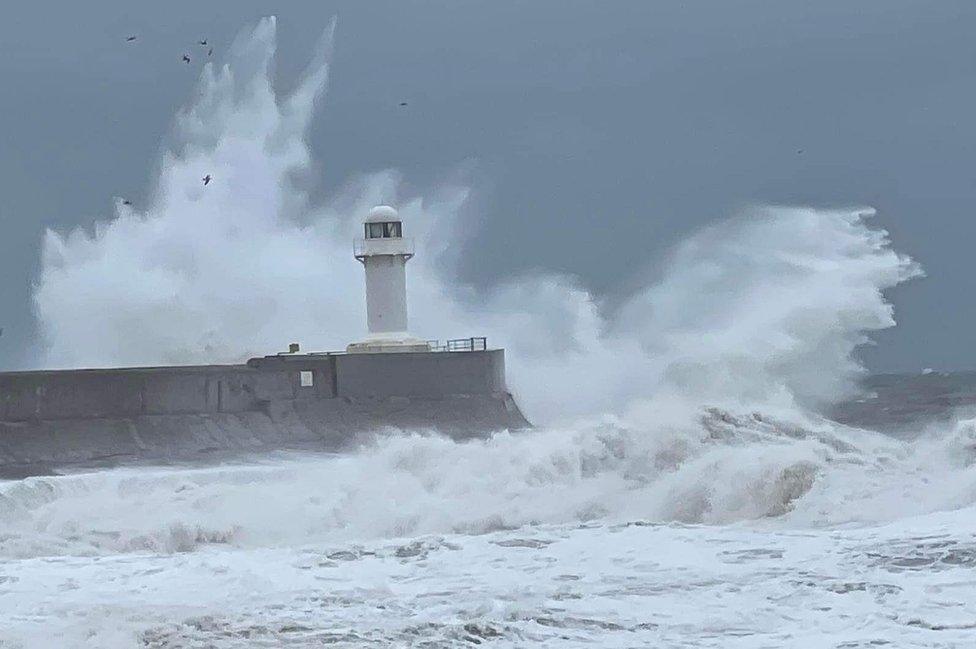 Waves break over a lighthouse