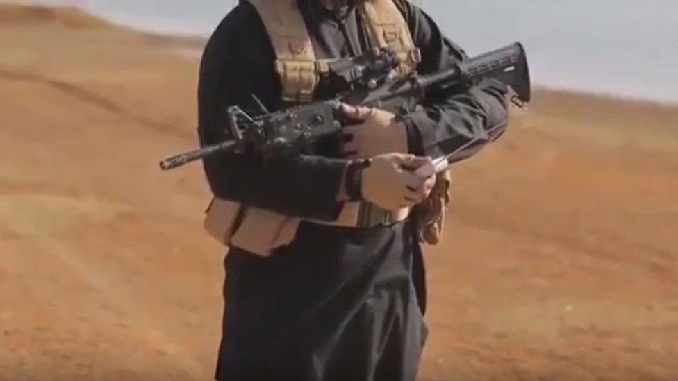 Screenshot from the execution video showing an IS solider armed with a rifle and radio transmitter