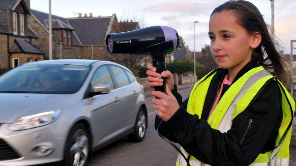 Girl using hairdryer as speed camera