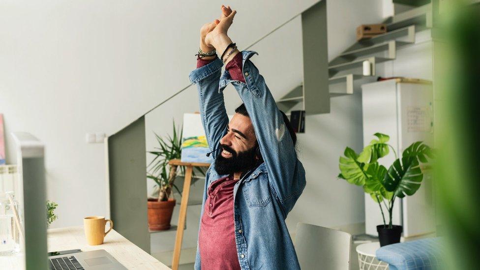 picture of someone stretching at their desk