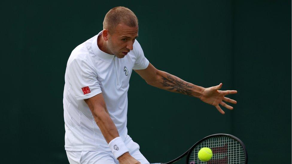 dan evans hits a tennis ball with a backhand