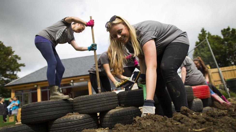 Volunteers digging and working with tyres