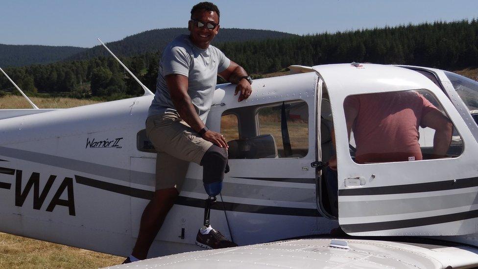 Louis Farrell leaning against a light aircraft