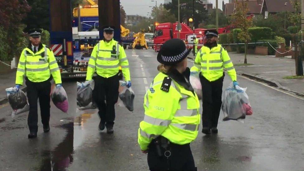 Police with bags of evidence