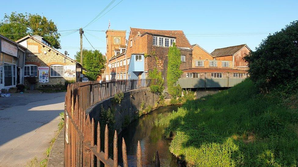 The Tower Building at St Michael's Trading Estate in Bridport and the River Brit in the foreground