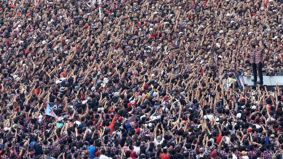 Basuki Tjahaja Purnama (right) before a big crowd of people raising their hands, at a rally in Jakarta Indonesia, February 11, 2017.