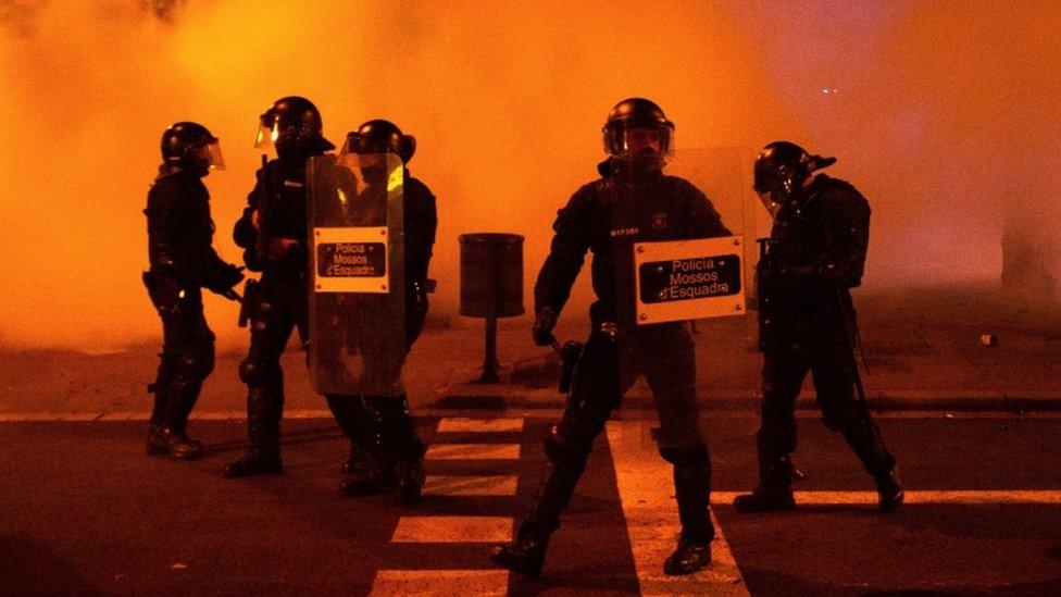 Riot police officers stand guard during a march to condemn the imprisonment of Spanish rapper