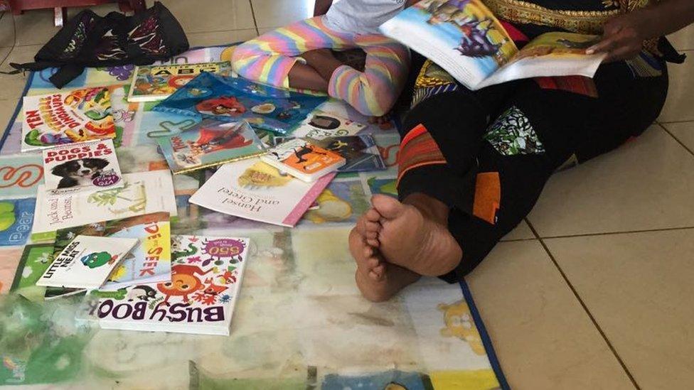 Beverley Nambozo reading with her daughter Zion, aged seven, in Kampala, Uganda