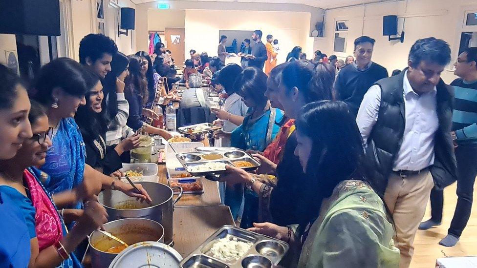 People gathered in a hall for a Puja